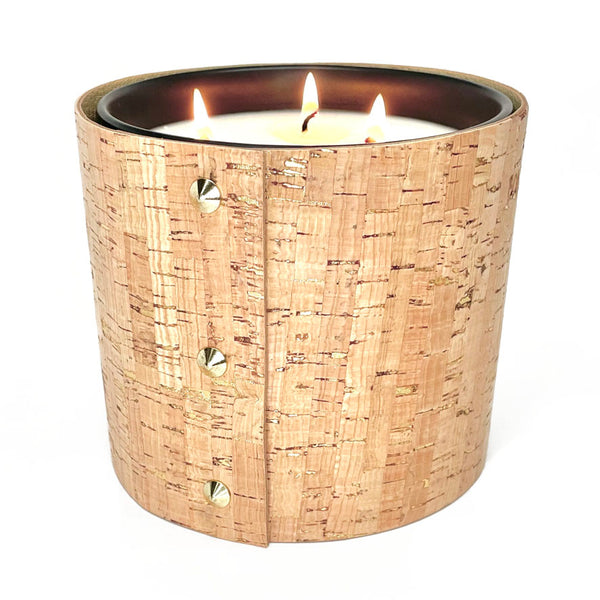large 3 -wick all natural soy candle is wrapped in cork with glistening gold inlays and 3 gold cone shaped studs