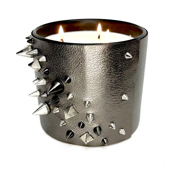 Large 3-wick soy candle in metallic gunmetal grey leather with several cone and pyramid studs in black and silver
