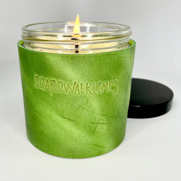 Luxury all natural soy candle sits in a spring green leather sleeve with 2 oil rubbed black studs 
