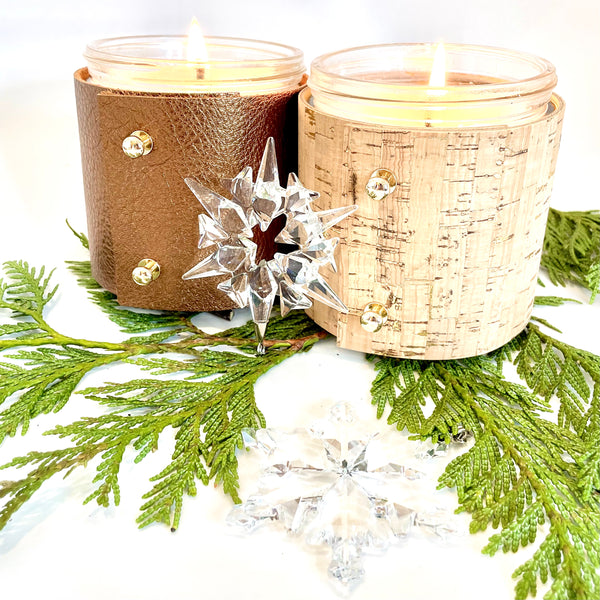Two winter candles filled with soy wax  arw wrapped in cork with gold inlays and metallic bronze leather.