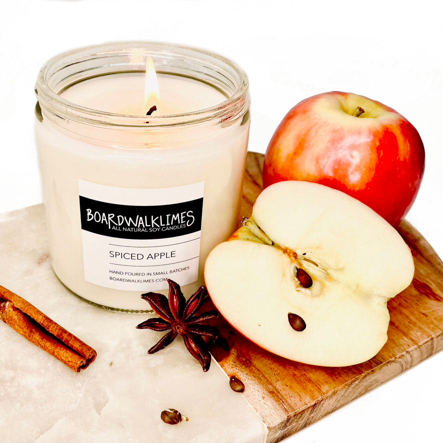 Luxury all scented soy candle with apples and cinnamon in a clear glass jar