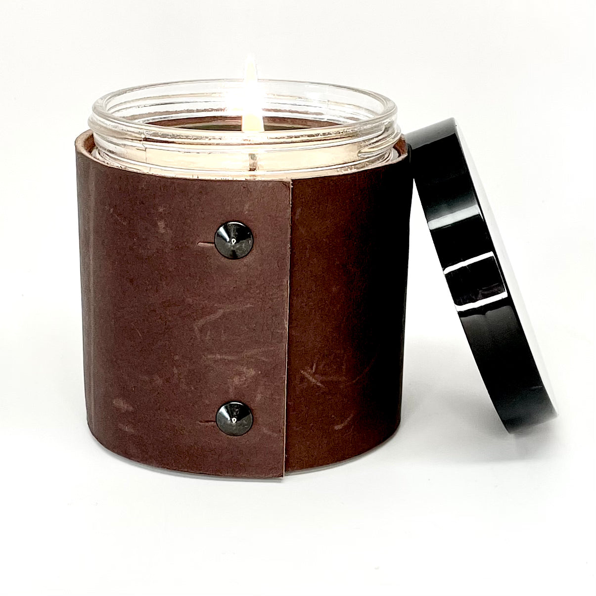 soy candle wrapped in rugged brown leather with 2 oil rubbed black studs