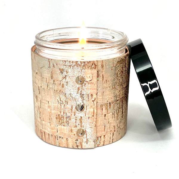 An all natural luxury soy candle wrapped in cork with shimmering silver glaze and 3 shiny silver cone shaped studs