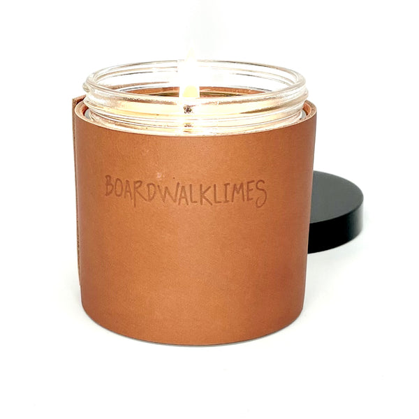All natural luxury soy candle wrapped in a caramel colored leather with 2 black studs 