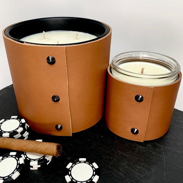 Luxury Large Soy 3-Wick Candle with a spiced honey, bourbon and smoke scent in a caramel colored fine leather wrap with oil rubbed black studs, smaller 1-wick soy candle in caramel colored fine leather wrap