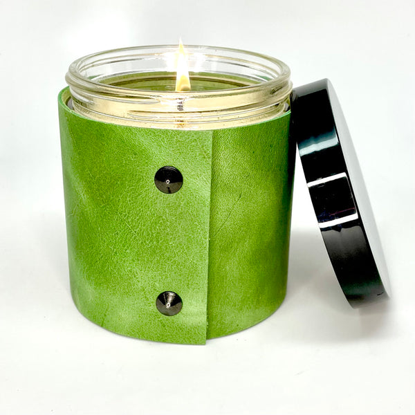 Luxury all natural soy candle sits in a spring green leather sleeve with 2 oil rubbed black studs