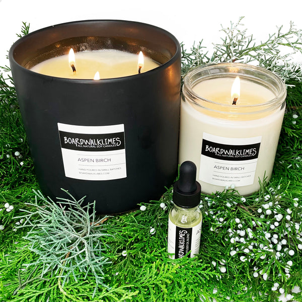 Luxury large soy candle with 3 wicks in Aspen evergreen fragrances in aa handmade black ceramic vase and a 1 wick soy candle in an Aspen evergreen scent