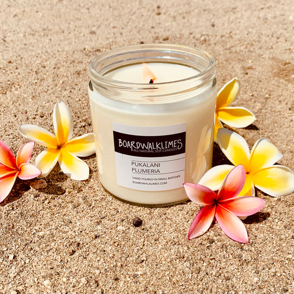 Hawaiian notes of plumeria fill this floral scented soy candle in a clear glass say with a shiny black modern lid
