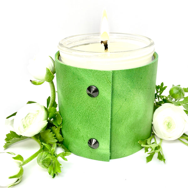 Luxury all natural soy candle sits in a spring green leather sleeve with 2 oil rubbed black studs