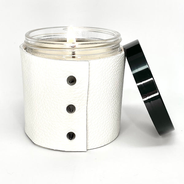 Large 1-wick luxury scented soy candle wrapped in fine white leather sleeve with 3 cone shaped studs and a shiny black lid