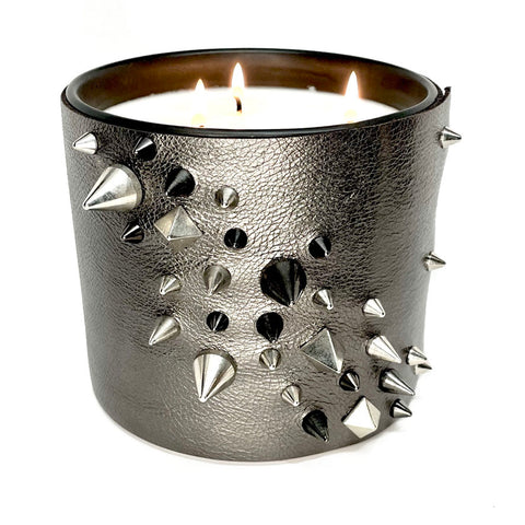 Large 3-wick soy candle in metallic gunmetal grey leather with several cone and pyramid studs in black and silver