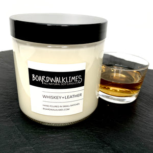Whiskey and leather scented 16 oz luxury soy candle in modern clear glass jar with shiny back lid