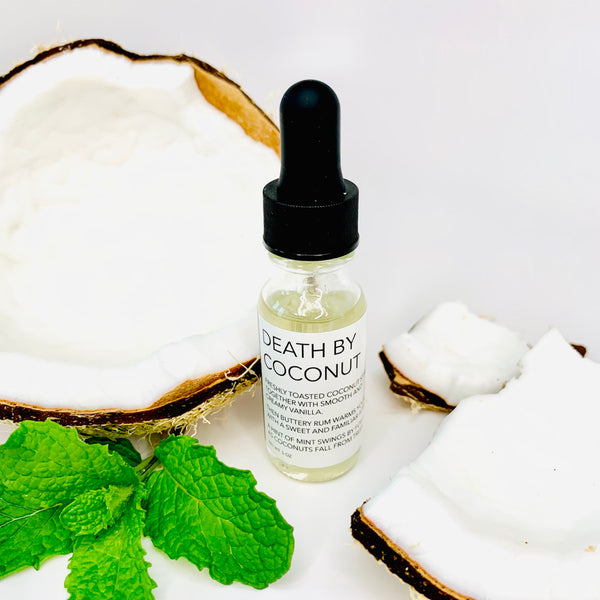 Coconut scented fragrance oil for essential oil diffusers in a modern clear glass boston round bottle with a black dropper lid
