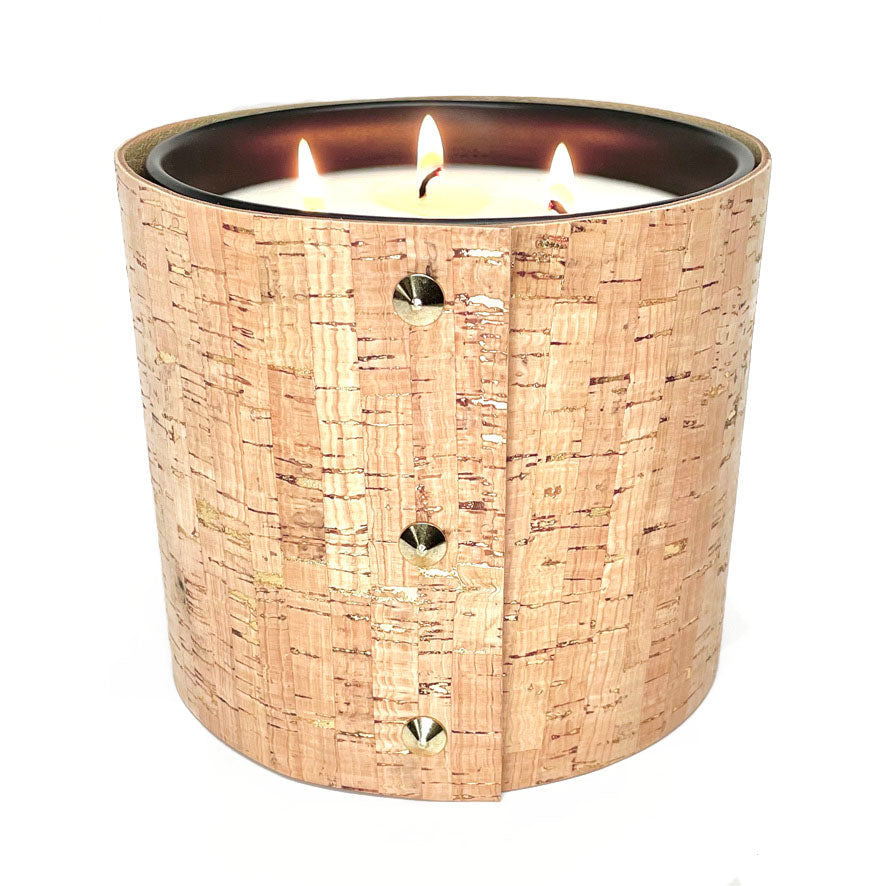 large 3 -wick all natural soy candle is wrapped in cork with glistening gold inlays and 3 gold cone shaped studs